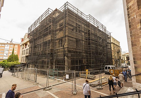 Vecinos caminan junto al edificio, ya en fase de demolición, entre las calles Ave María y Serafín Escalante de Torrelavega.