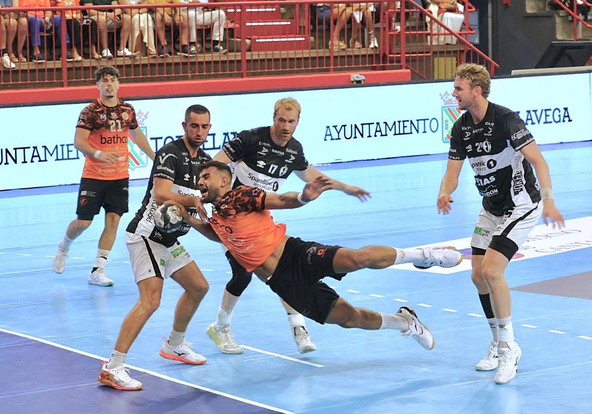 Marcio Silva busca el disparo mientras le agarra un jugador del Elverum.