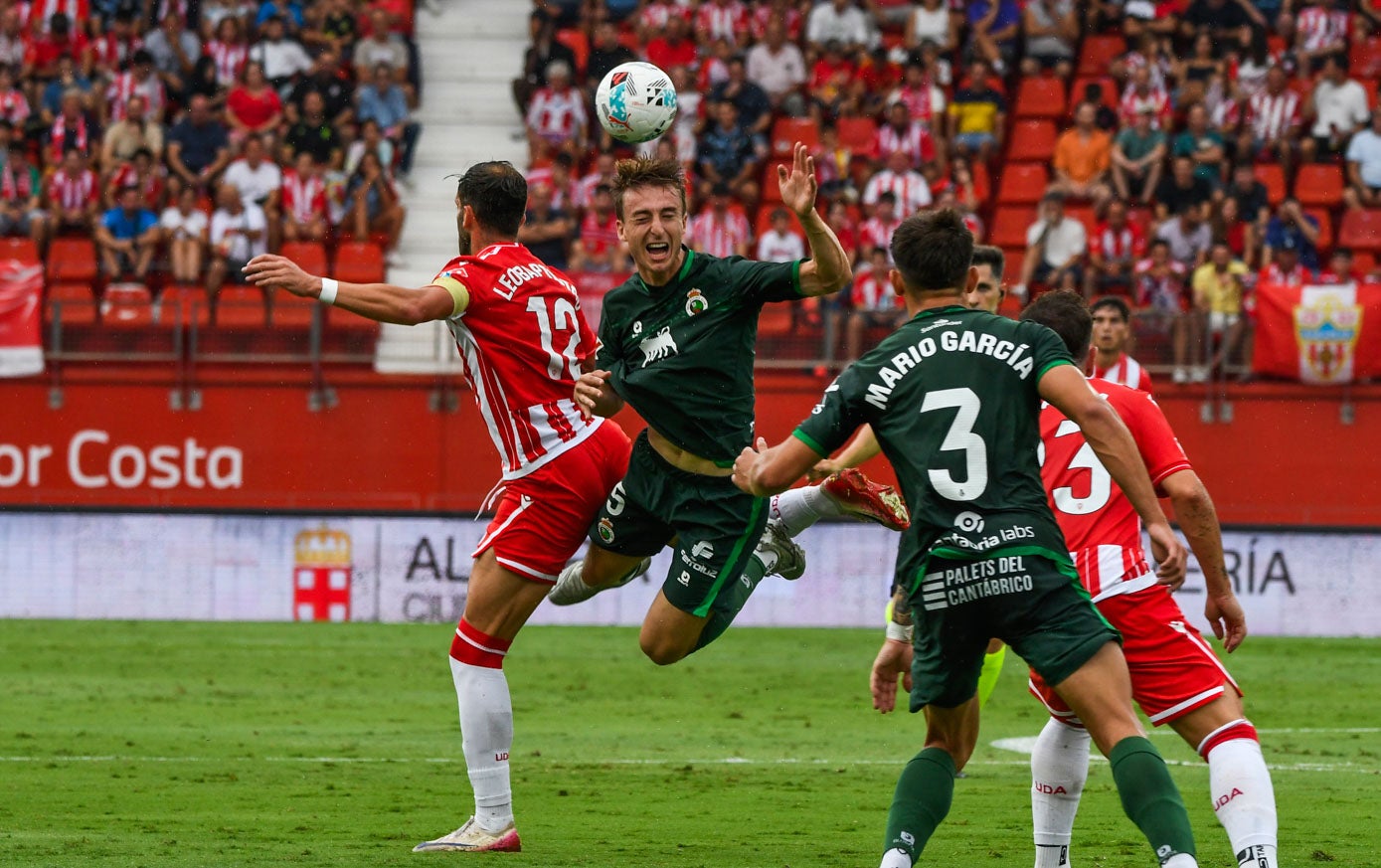 Javi Castro despeja de cabeza un balón ante Leo Baptistao.