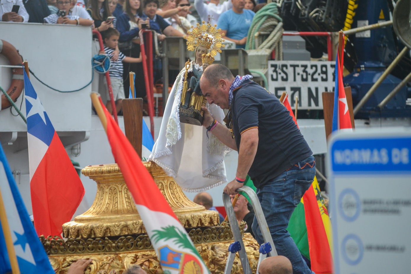 La talla es bajada de la carroza al llegar al puerto pesquero.