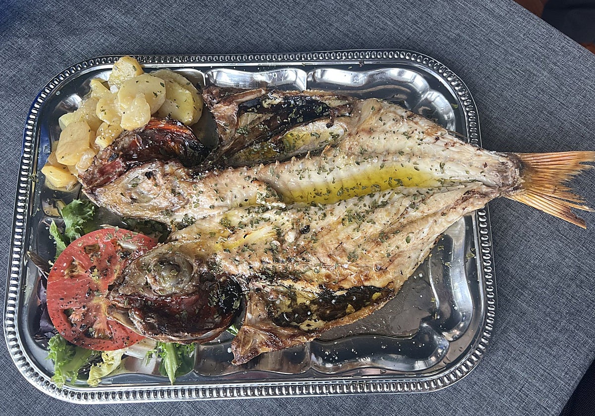 Besugo de un kilo y medio, preparado a la brasa, con guarnición de patata y ensalada.