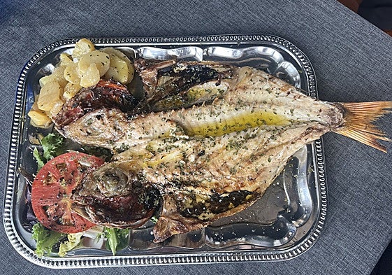 Besugo de un kilo y medio, preparado a la brasa, con guarnición de patata y ensalada.