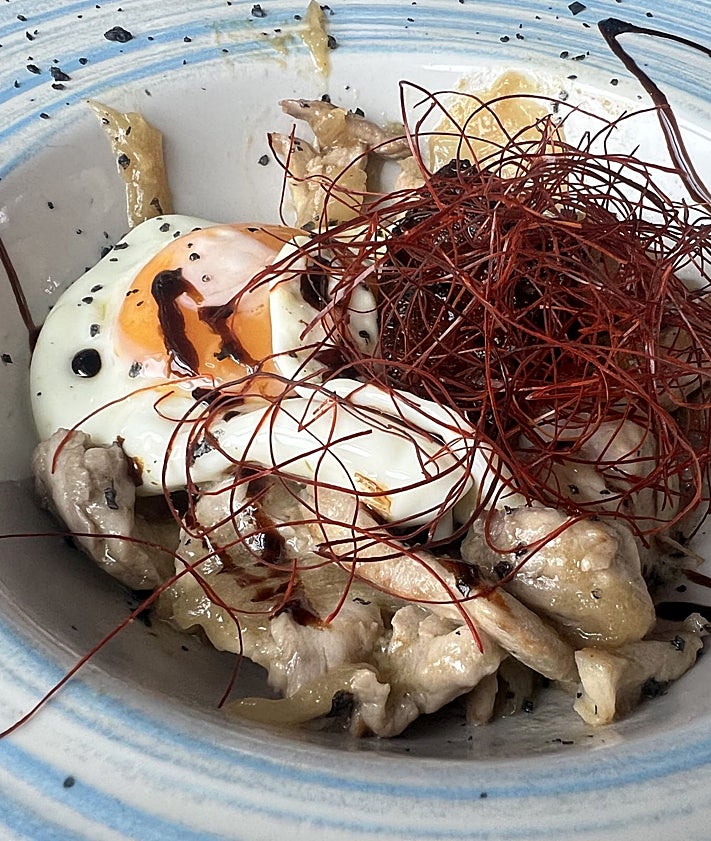 Imagen secundaria 2 - Rafael Cimiano y Aida Fernández, propietarios junto a algunos de los platos que presentan en carta: media ración de rabas y unos tacos de bonito con huevo escalfado, cebolla y foie.