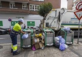 Uno de los trabajadores de la empresa PreZero, adjudicataria del servicio de emergencia, ayer, recoge la basura de los contenedores neumáticos de la calle Castilla Hermida.