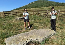 Paula García y Pablo Sotres, guías de la Mancomunidad del Nansa, ante uno de los menhires más interesantes de todo el conjunto.