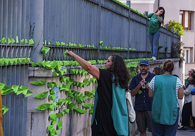 La verja del Paraninfo se ha llenado de barcos de papel verde.