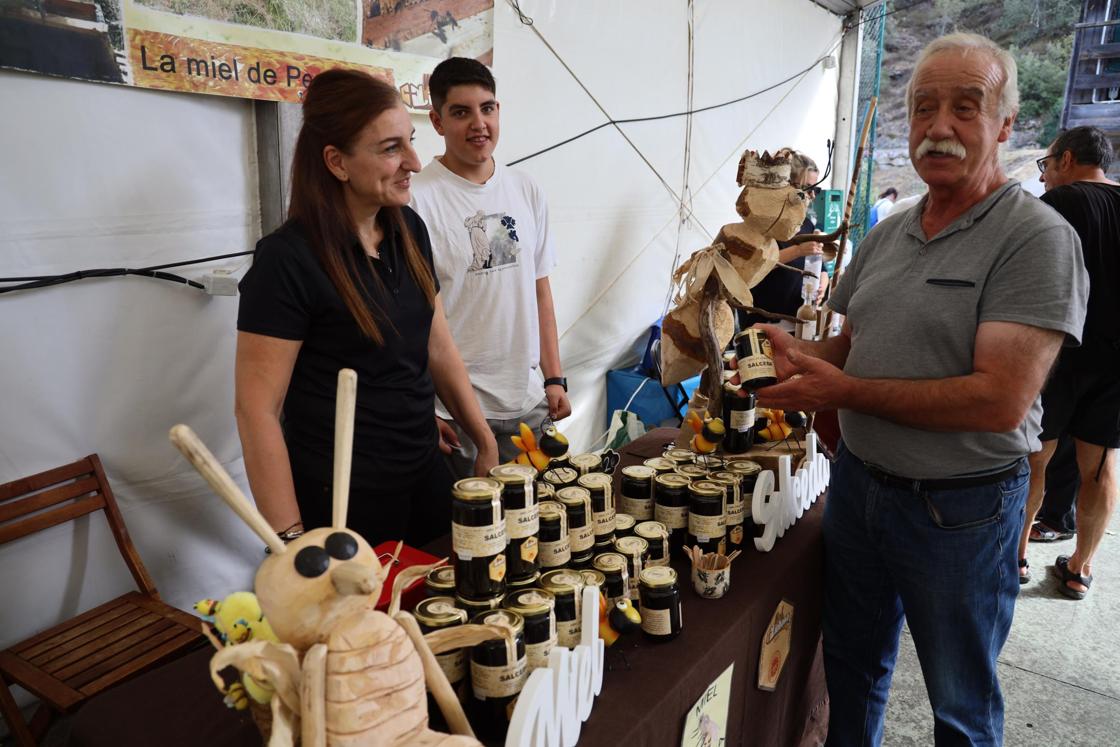Un hombre enseña uno de los productos de uno de los puestos de miel. 