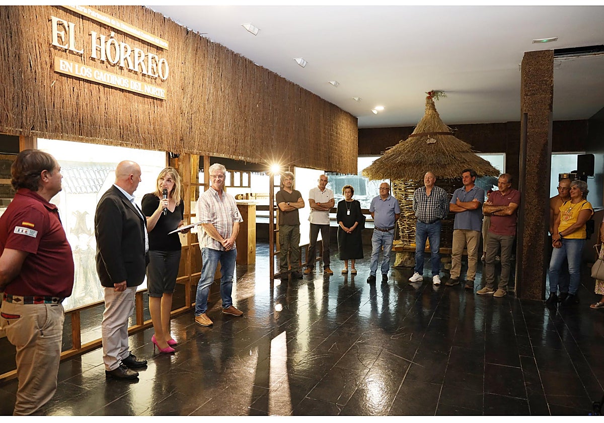 Imagen principal - Pilar Gómez Bahamonde durante su intervención; el Canasto de Baras, portugués, que se muestra en la exposición, y el alcalde de Cillorigo de Liébana, Jesús Cuevas, contemplando la maqueta del hórreo cántabro de Anievas