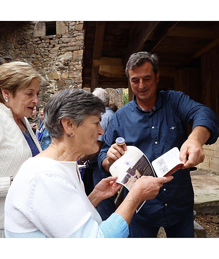 Imagen secundaria 2 - Los propietarios del hórreo recibieron una maqueta en relieve; entrega de la llave del hórreo por parte de los propietarios al alcalde, Enrique Sabarís, y el alcalde entregando sellada la credencial del Camino Lebaniego a dos vecinas