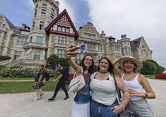 Tres turistas se hacen un selfie junto al Palacio de La Magdalena, en Santander.