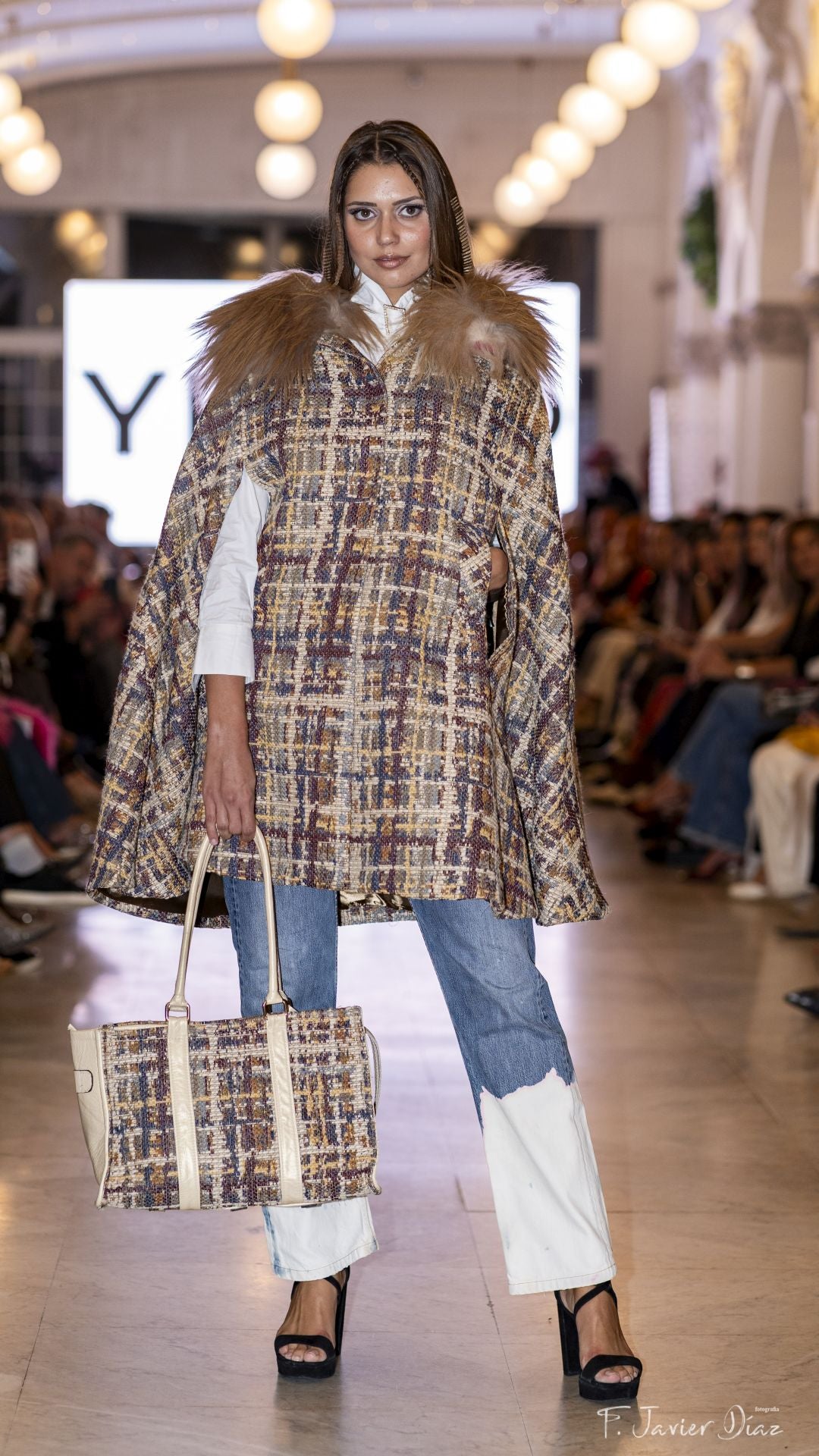 Abbie Potter, con capa, pantalón y bolso de YES50.