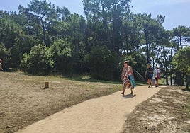 Vecinos de Somo atraviesan la senda del Monte Arna para acceder a la playa.