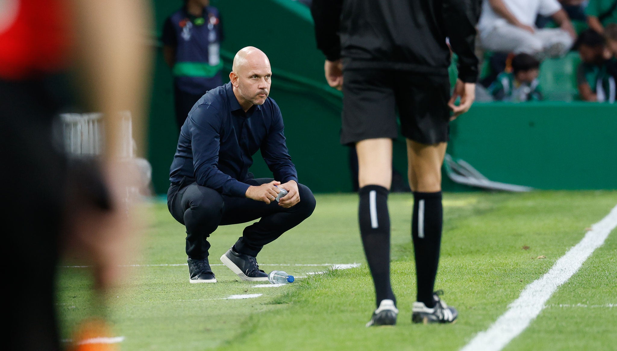 José Alberto, agachado en la banda, observa el partido
