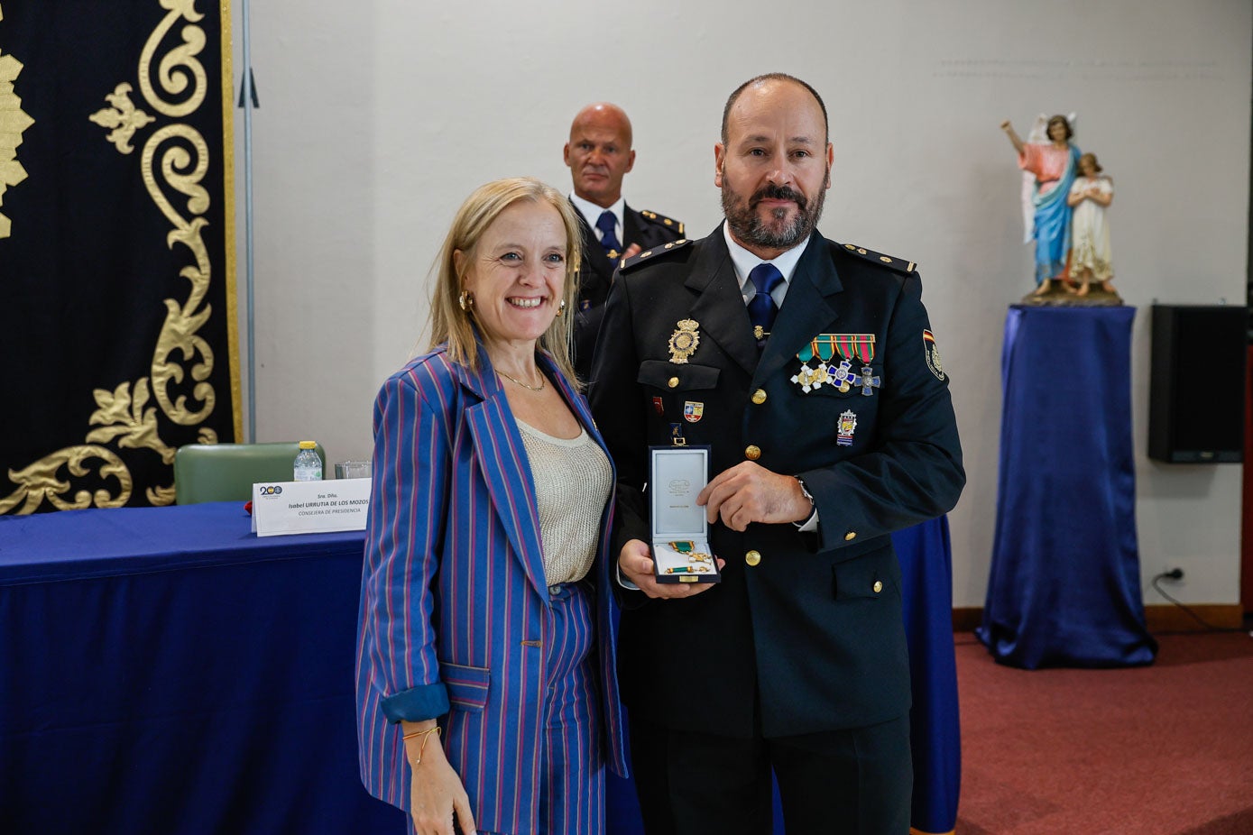 La consejera de Presidencia, Isabel Urrutia, junto a otro de los agentes que recibió la Cruz al Mérito Policial.