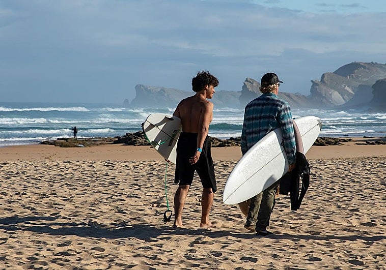 Tom Curren, a la derecha, se dirige al agua con su hijo Pat, en la playa de Liencres.