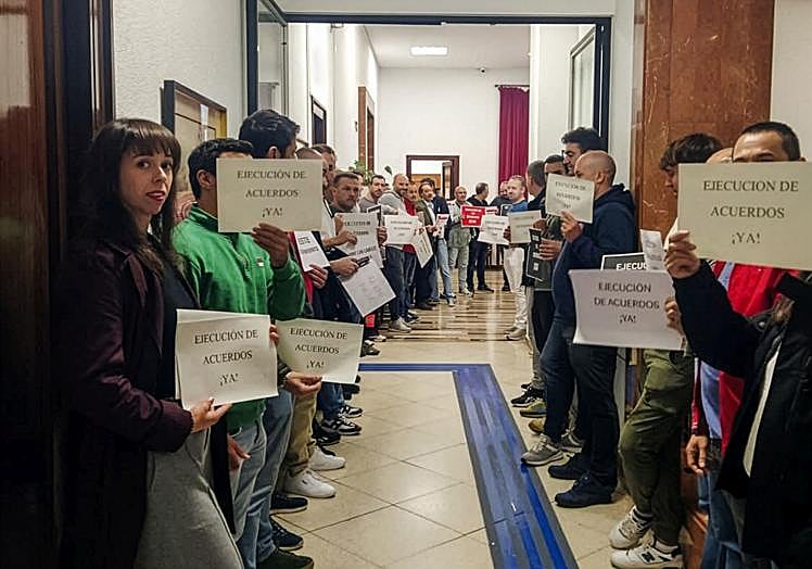 Una treintena de empleados públicos del Ayuntamiento de Santander protestan fueran del salón plenario, mientras esperan a que lleguen los concejales del equipo de gobierno del PP.