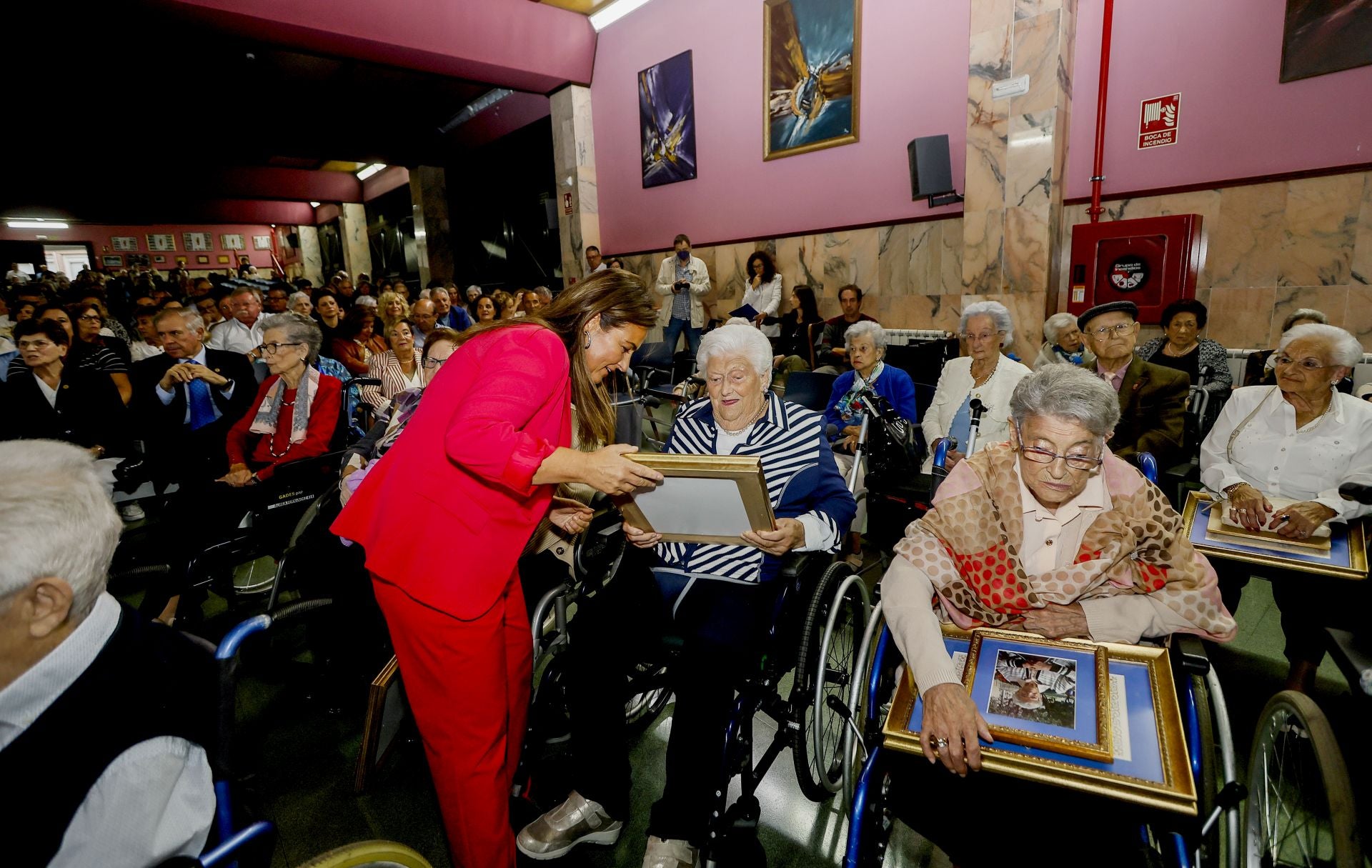 Gaspara Revuelta observa la distinción que acaba de recibir, junto a la consejera Begoña Gómez del Río.