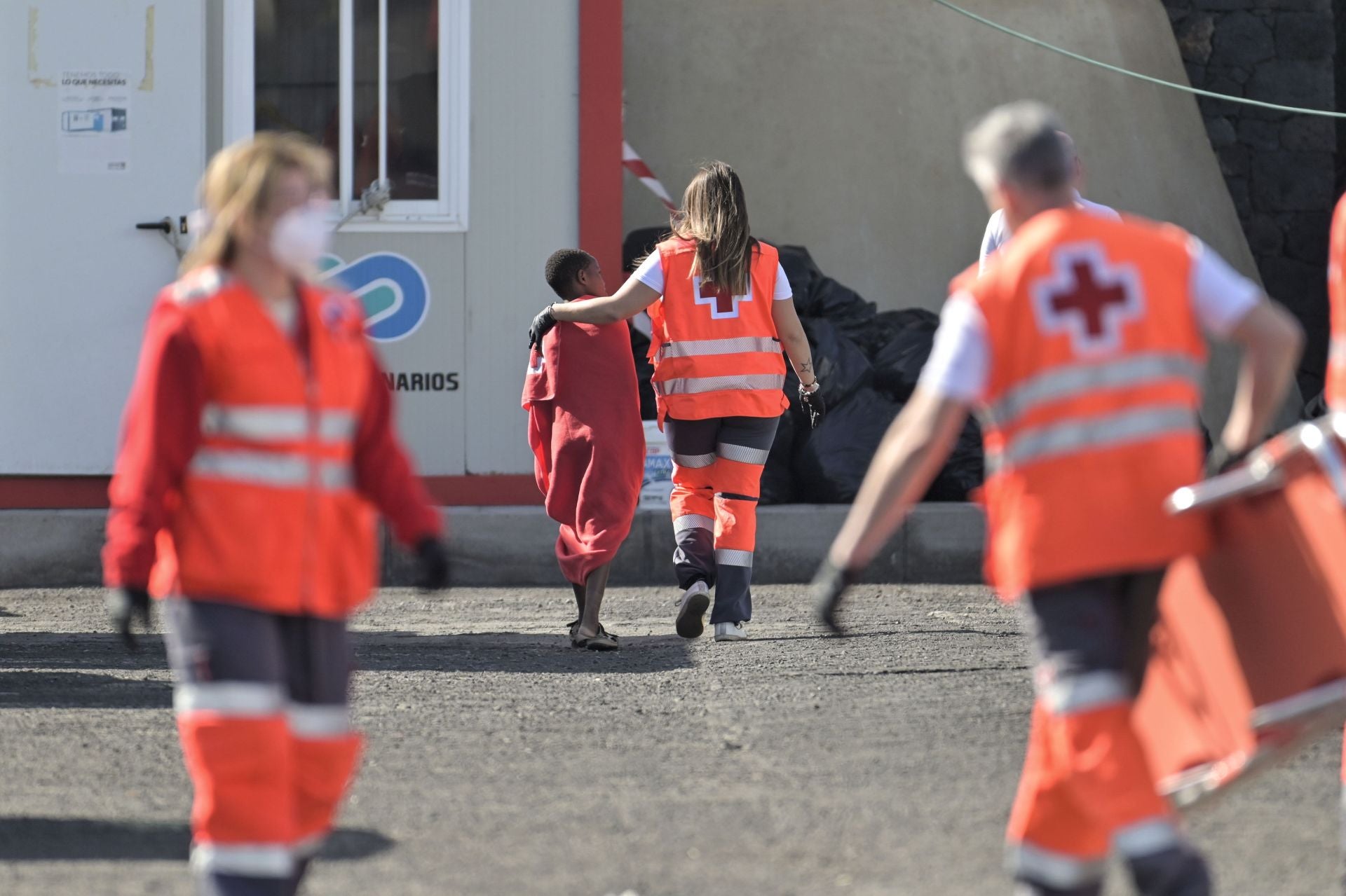 Miembros de Cruz Roja acompañan a niños migrantes en Canarias.