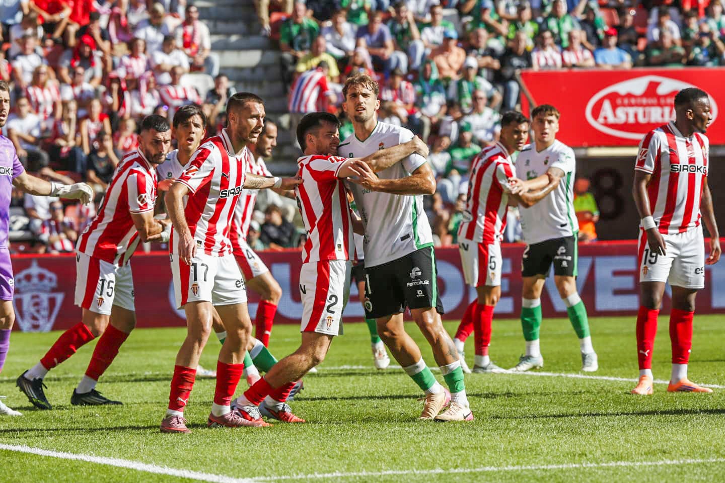 Pablo Ramón intenta colocarse a la salida de un córner a favor del Racing mientras los jugadores del Sporting intentan impedírselo
