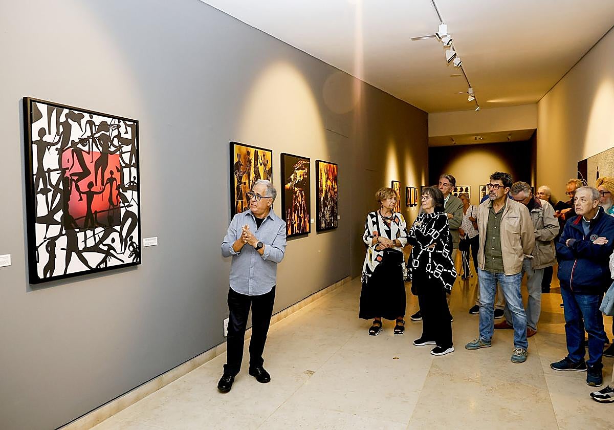 Miguel Ángel García explica, durante la inauguración de la muestra, el significado de una de sus pinturas.