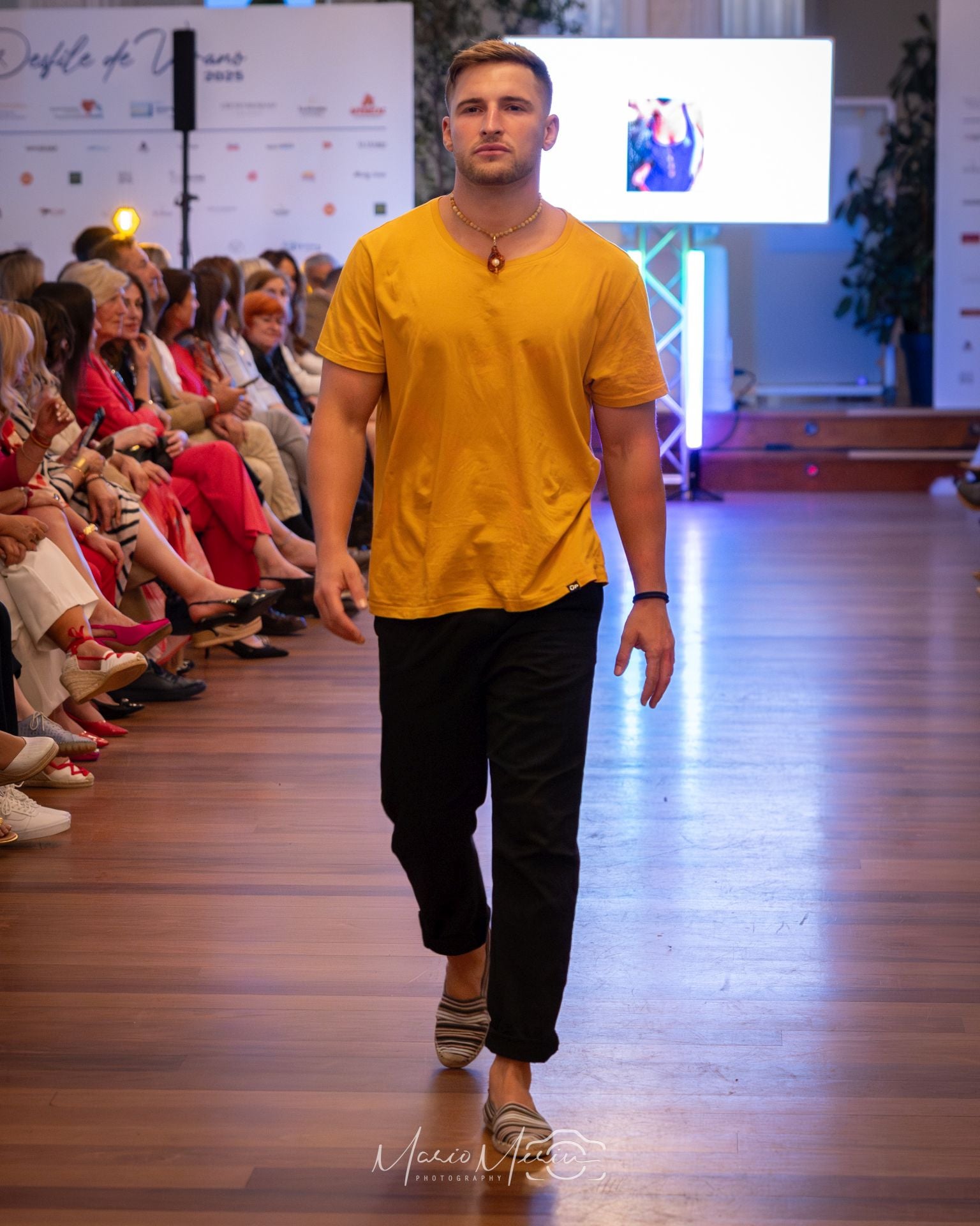 Vestido de sport con camiseta amarilla, pantalón negro y bambas a rayas.