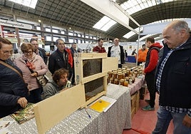 Visitantes se interesan por uno de los puestos de la Feria Nacional Apícola, en el Ferial de Torrelavega, en una edición anterior.