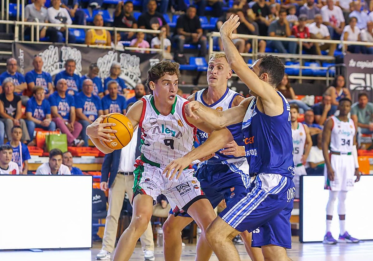 Lugarini, del Alega, defiende la pelota ante dos rivales