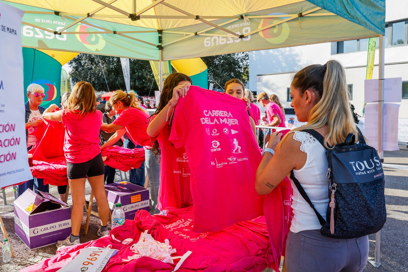 Una joven compra una camiseta para contribuir en la causa solidaria.