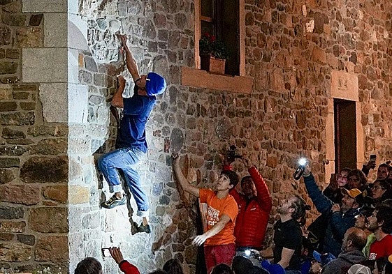 Un escalador, en la fachada de un edificio en Potes.