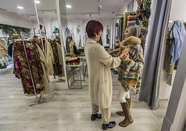 Dos mujeres se prueban ropa en un comercio local del centro de Santander.