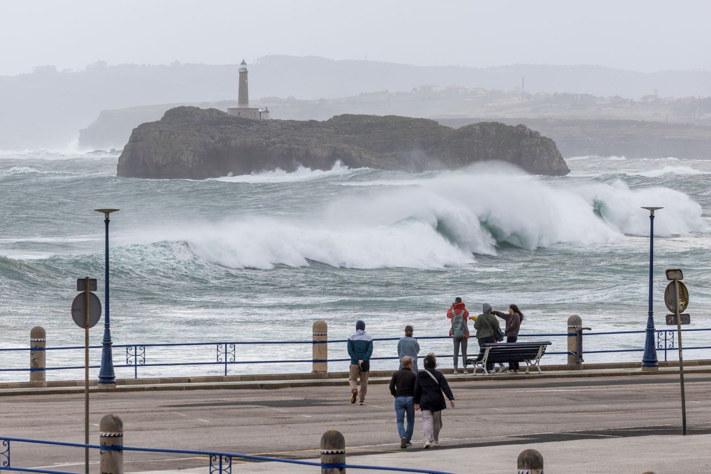 Curiosos en la zona del Camello contemplan como rompe el oleaje contra la isla de Mouro.