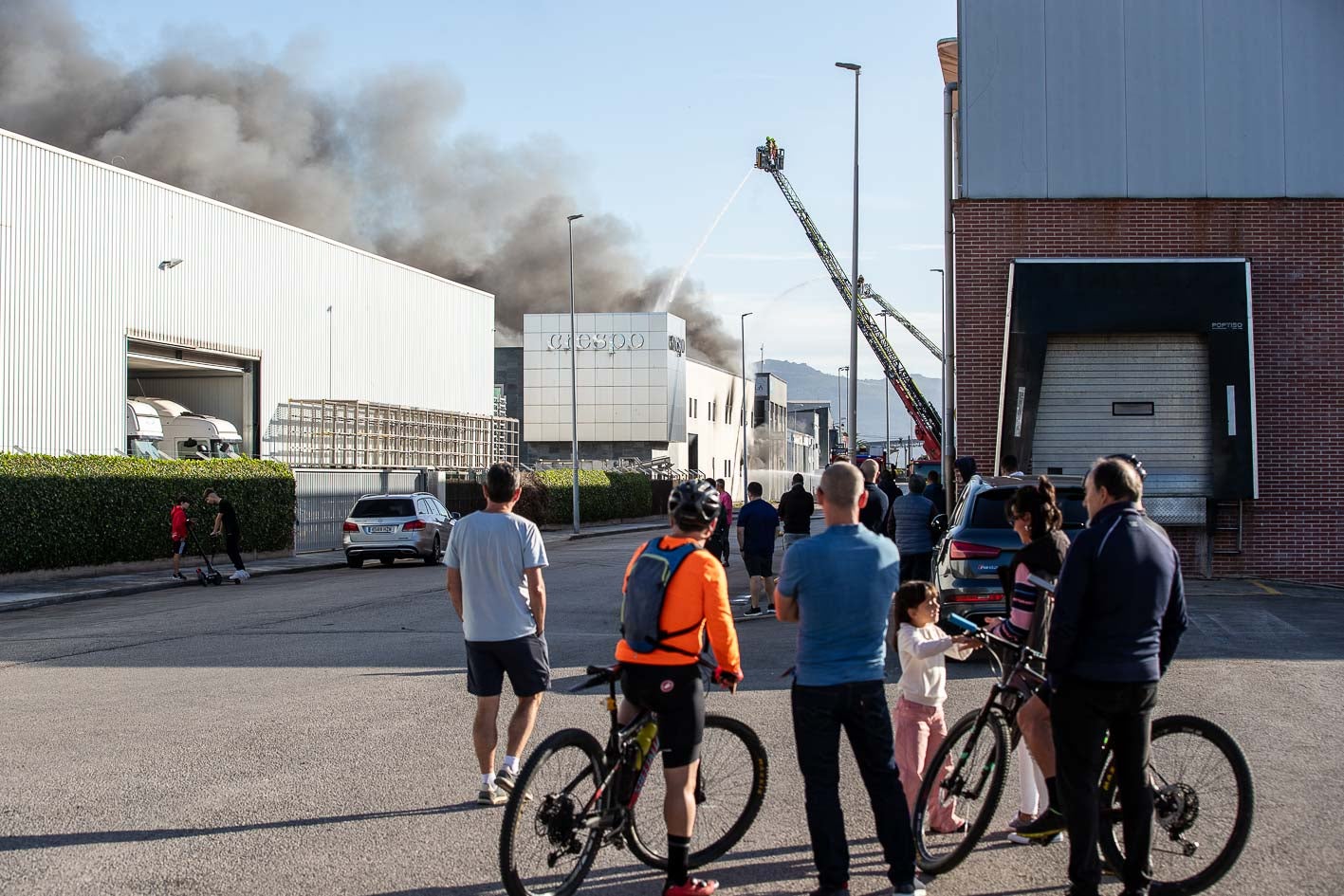 Unos vecinos contemplan las labores de extinción del fuego