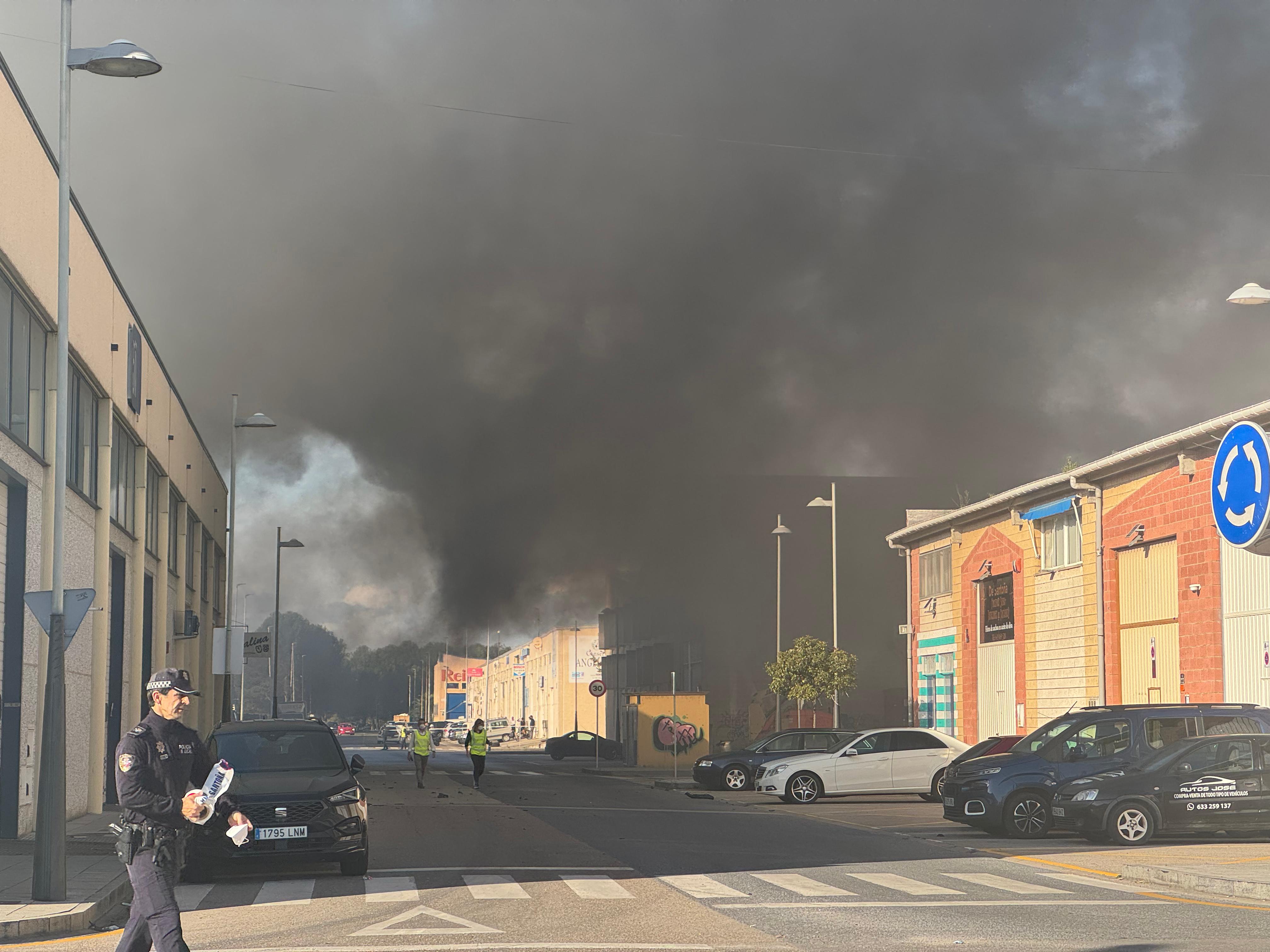 Un policía local con una mascarilla en la mano y agua para soportar el tóxico ambiente