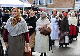 Un grupo de mujeres ataviadas de época desfilan por el mercado instalado en el popular barrio de La Pesa en Cabezón