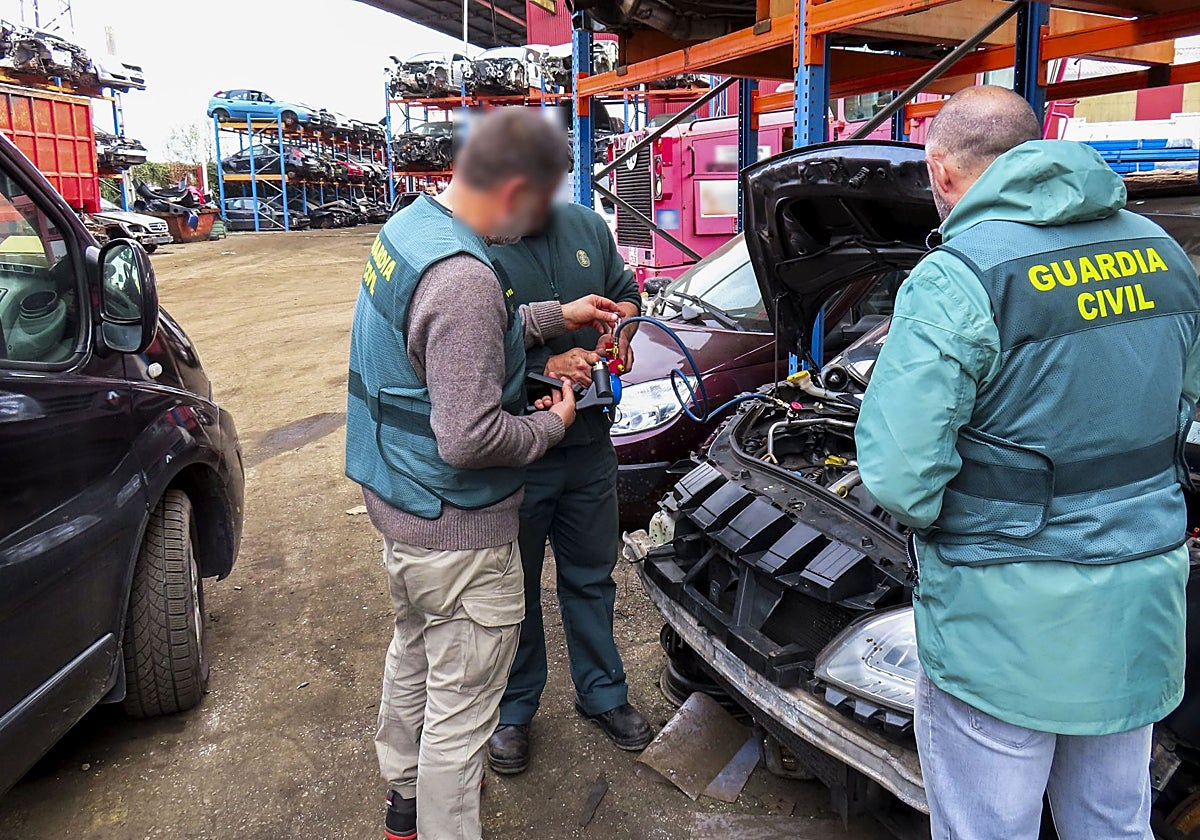 Agentes de la Guardia Civil revisan el aire acondicionado de un coche para comprobar si ha sido descontaminado correctamente.