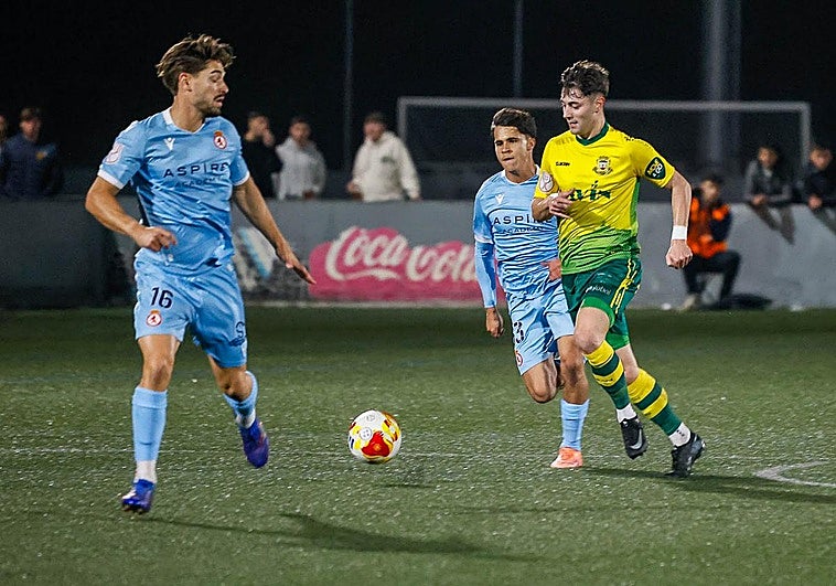 Fran, del Tropezón, conduce la pelota entre dos rivales