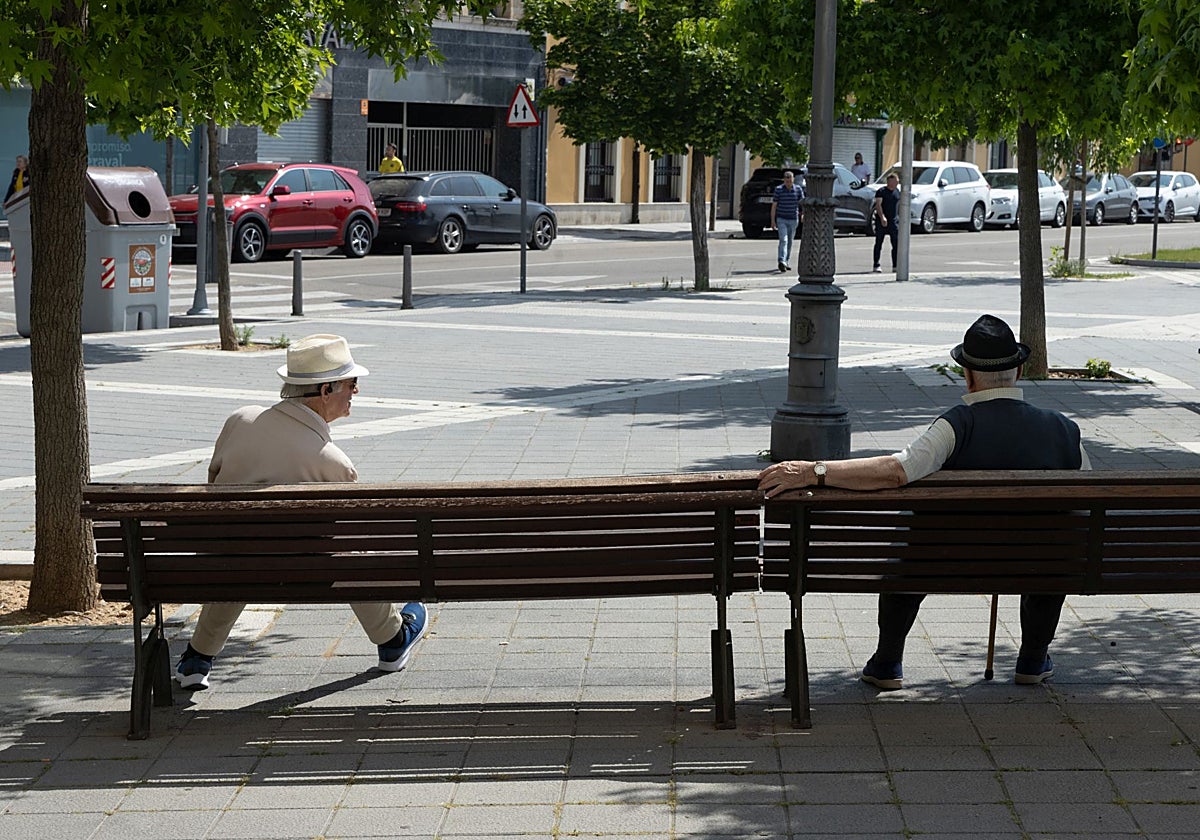 Dos jubilados sentados en un banco.