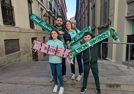 Una familia racinguista exhibe sus bufandas en la capital riojana en la previa del partido.