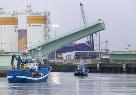 Dos embarcaciones pesqueras pasan bajo el puente levadizo de Raos.