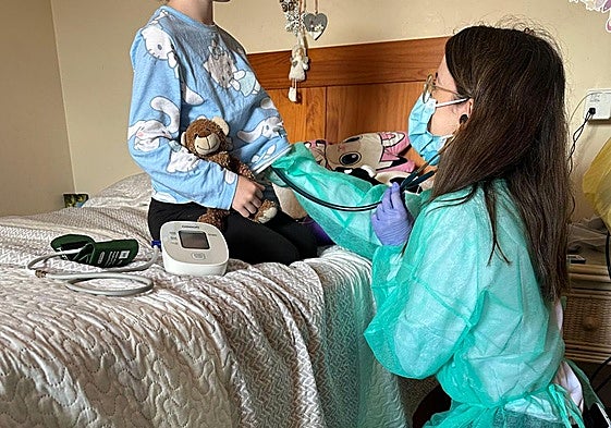 La pediatra Alejandra Coccolo examina a una niña hospitalizada en casa.