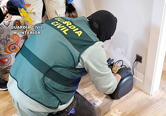 La Guardia Civil cuenta el dinero incautado en el piso con una máquina.