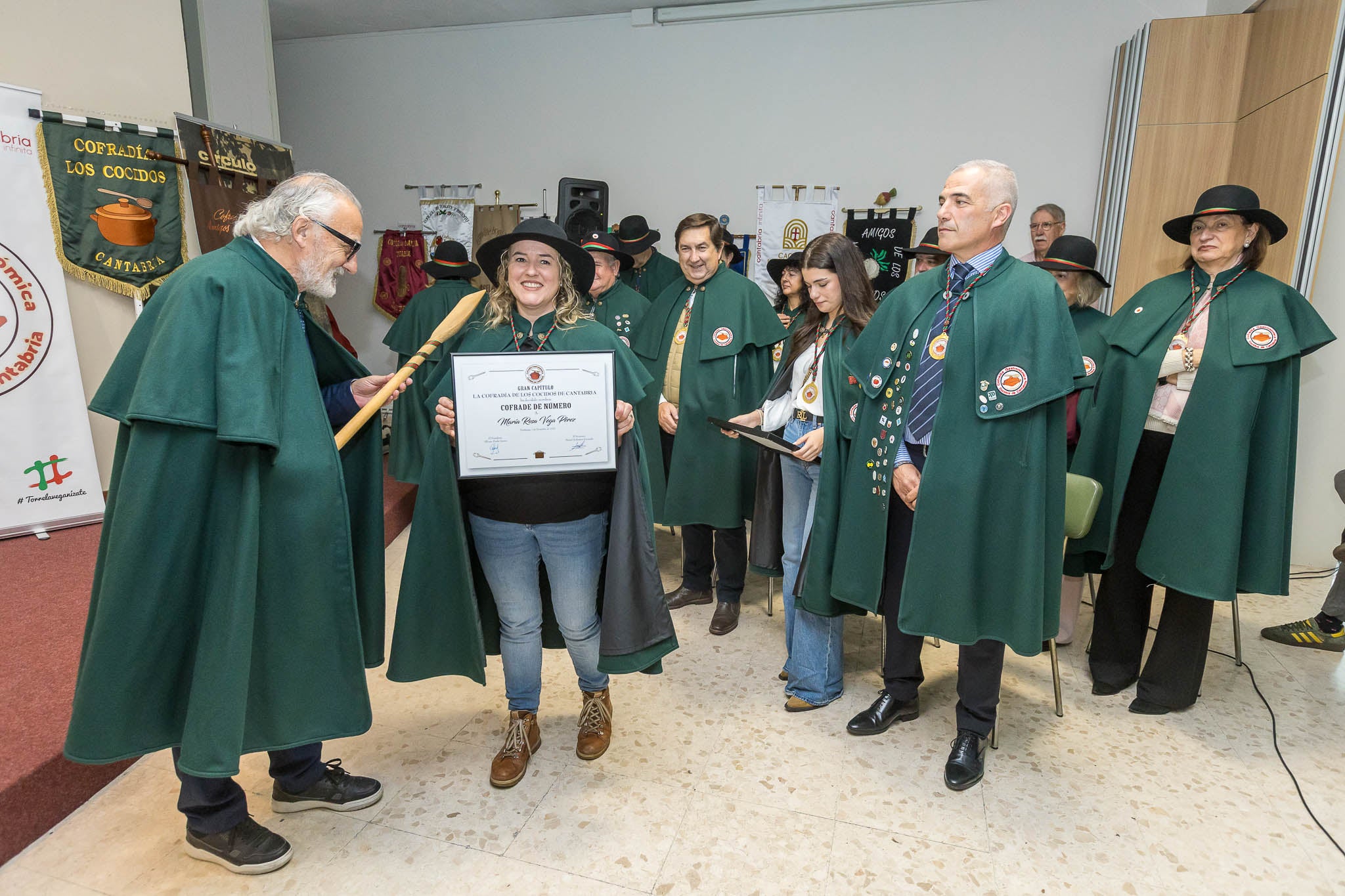 María Rosa Vega Pérez, una de las nuevas cofrades de la entidad, recibe su diploma junto al presidente, Alfonso Fraile, y el resto de nuevos miembros. 