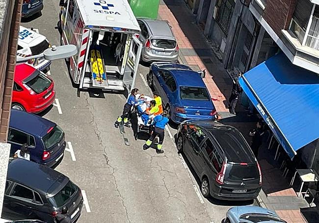 Los sanitarios evacúan al hombre tras la caída por la ventana.