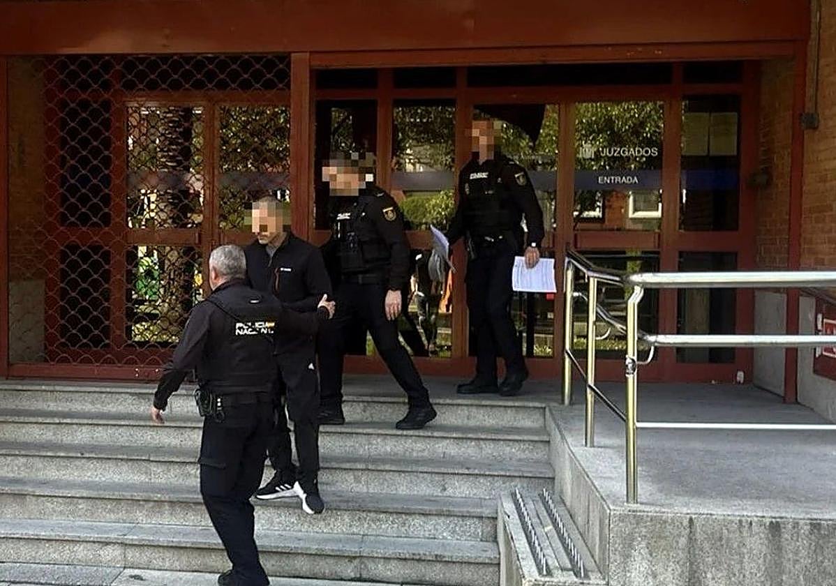 Agentes de la Policía Nacional custodian al detenido a la salida del juzgado de Mieres.