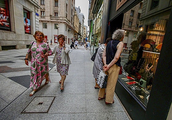Clientes observan un escaparate de Santander.