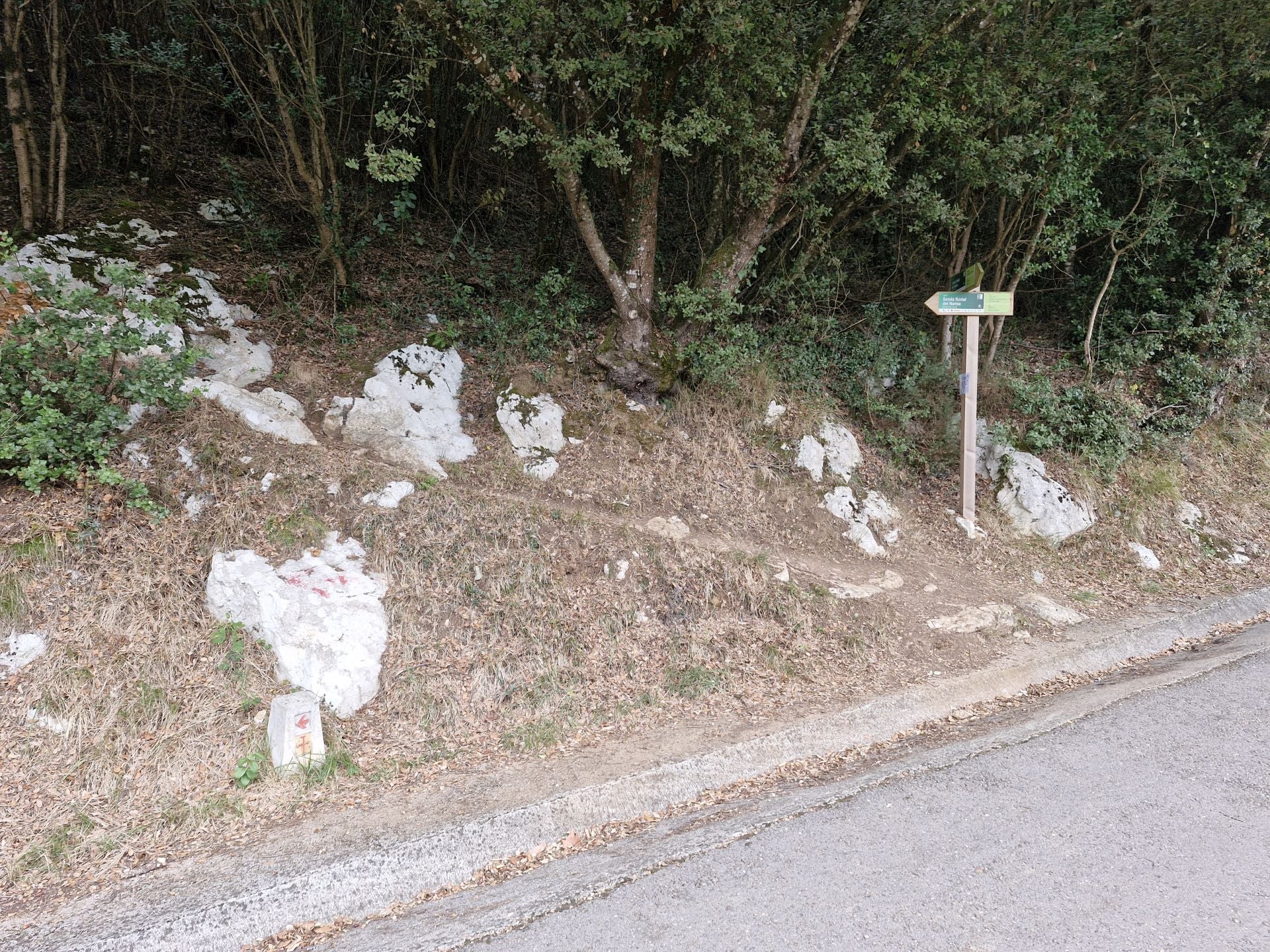 Tras pasar por el puente del Tortorio, esta señal indica que hay que retomar la senda monte a través.
