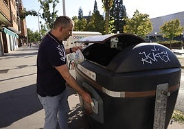 Un hombre, en Vitoria, deposita residuos orgánicos en un contenedor tras abrirlo con su tarjeta.
