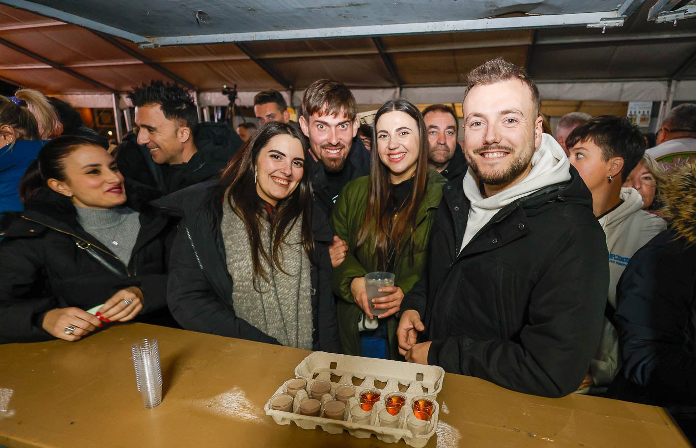 Jóvenes cántabros degustan el orujo con los vasos de chupito en la típica huevera.