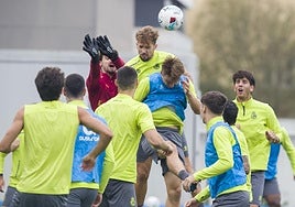 Jokin Ezkieta se dispone a despejar ante el intento de remate de Pablo Ramón en un entrenamiento del Racing en La Albericia.