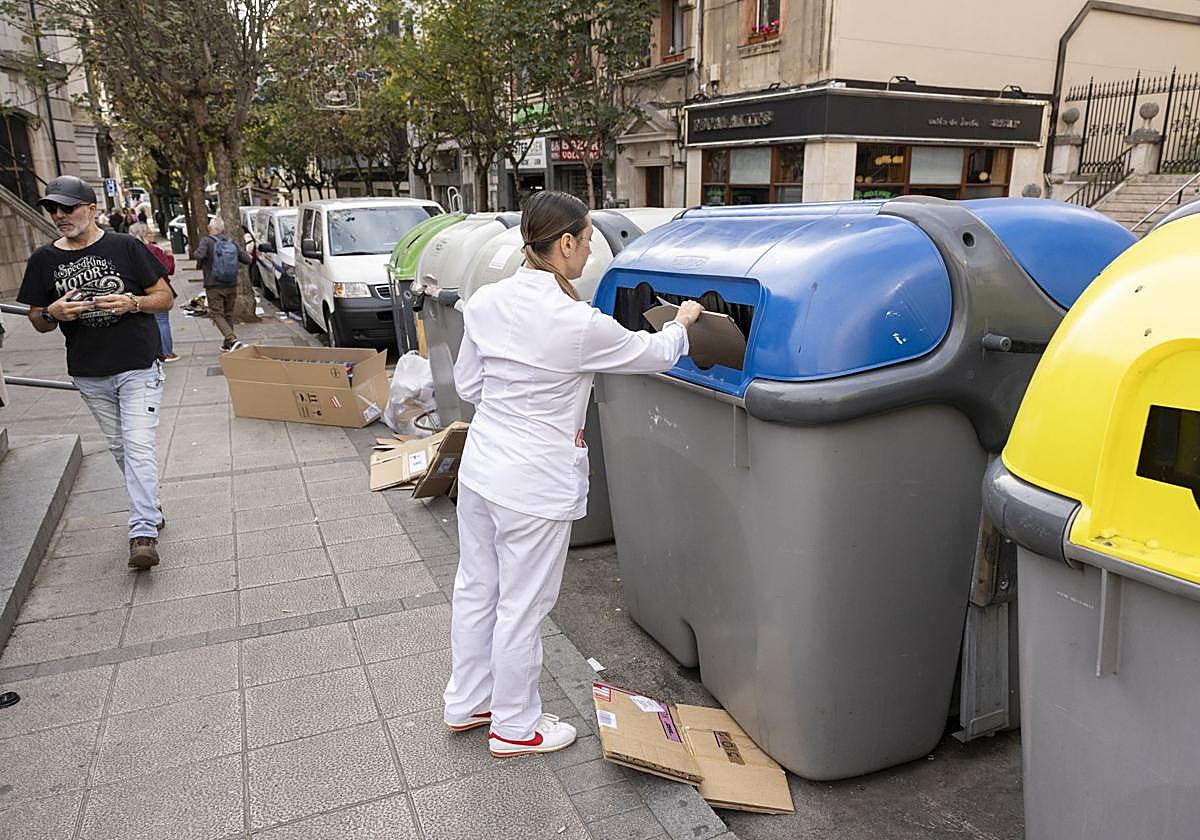 Una mujer tira la basura junto al Mercado de la Esperanza, en Santander.